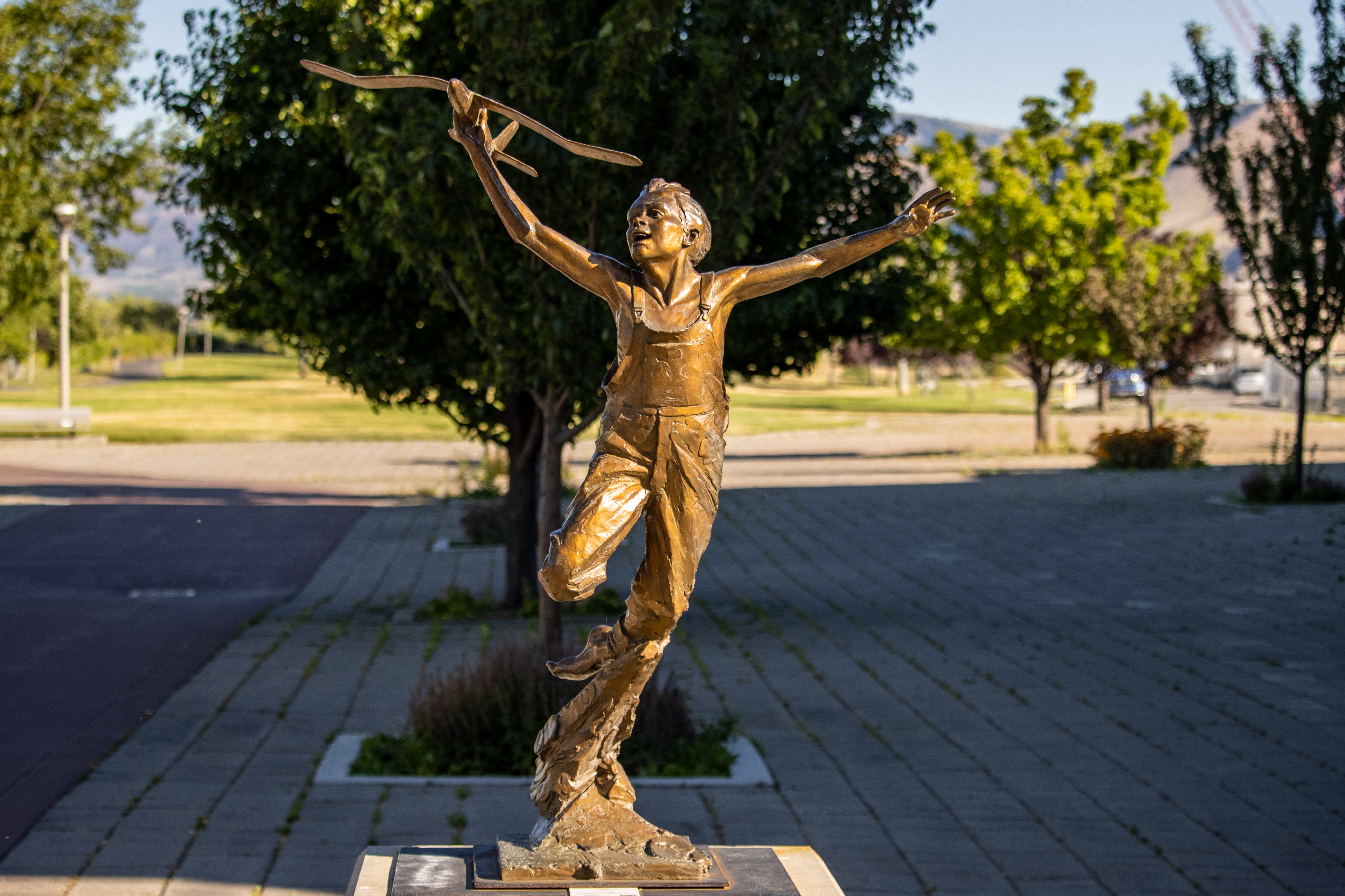 Statue in Wenatchee of a little boy playing with an airplane 